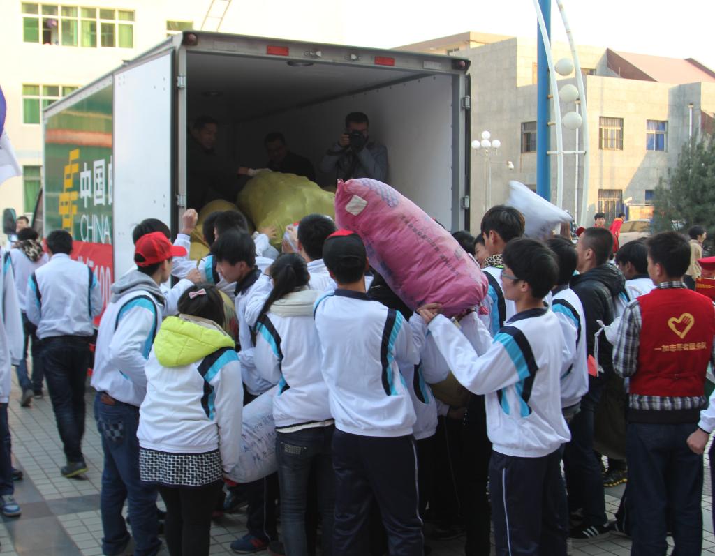 志愿者将衣服搬运上邮车